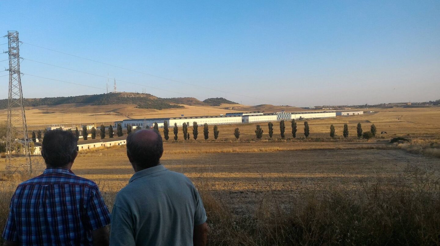 Dos hombres contemplan la Base de Mantenimiento Integral de Renfe desde un alto, en Valladolid.