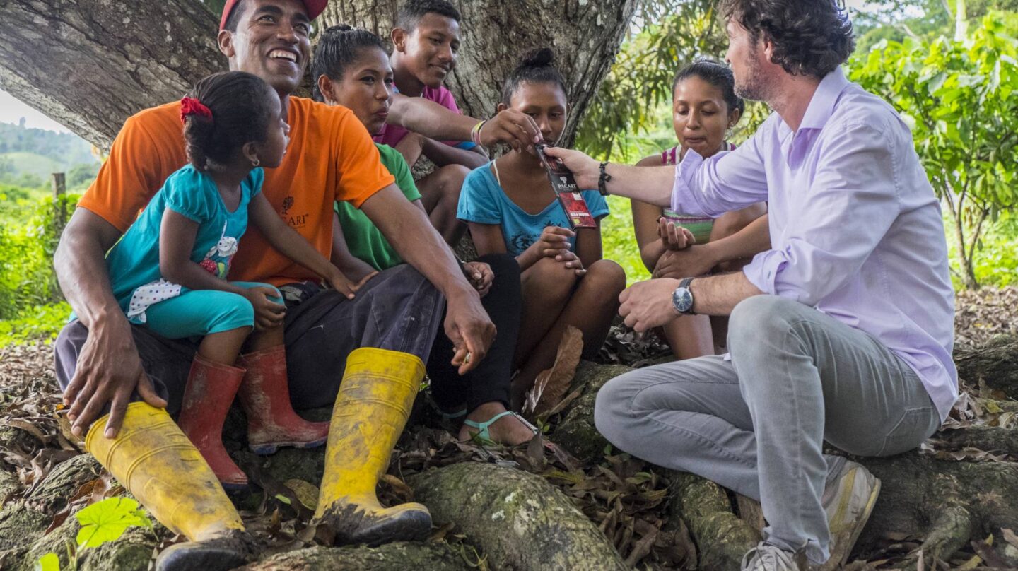 Santiago Peralta (a la dcha.) ofrece chocolate a una familia de campesinos.