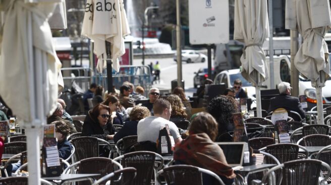 Personas en una terraza en Madrid España cierra la peor crisis de su historia con más de 16 millones de personas inactivas.