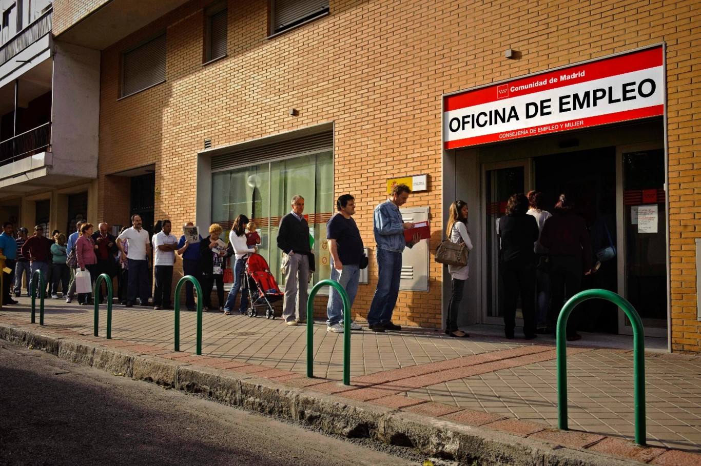 Desempleados españoles hacen cola en una oficina de empleo.