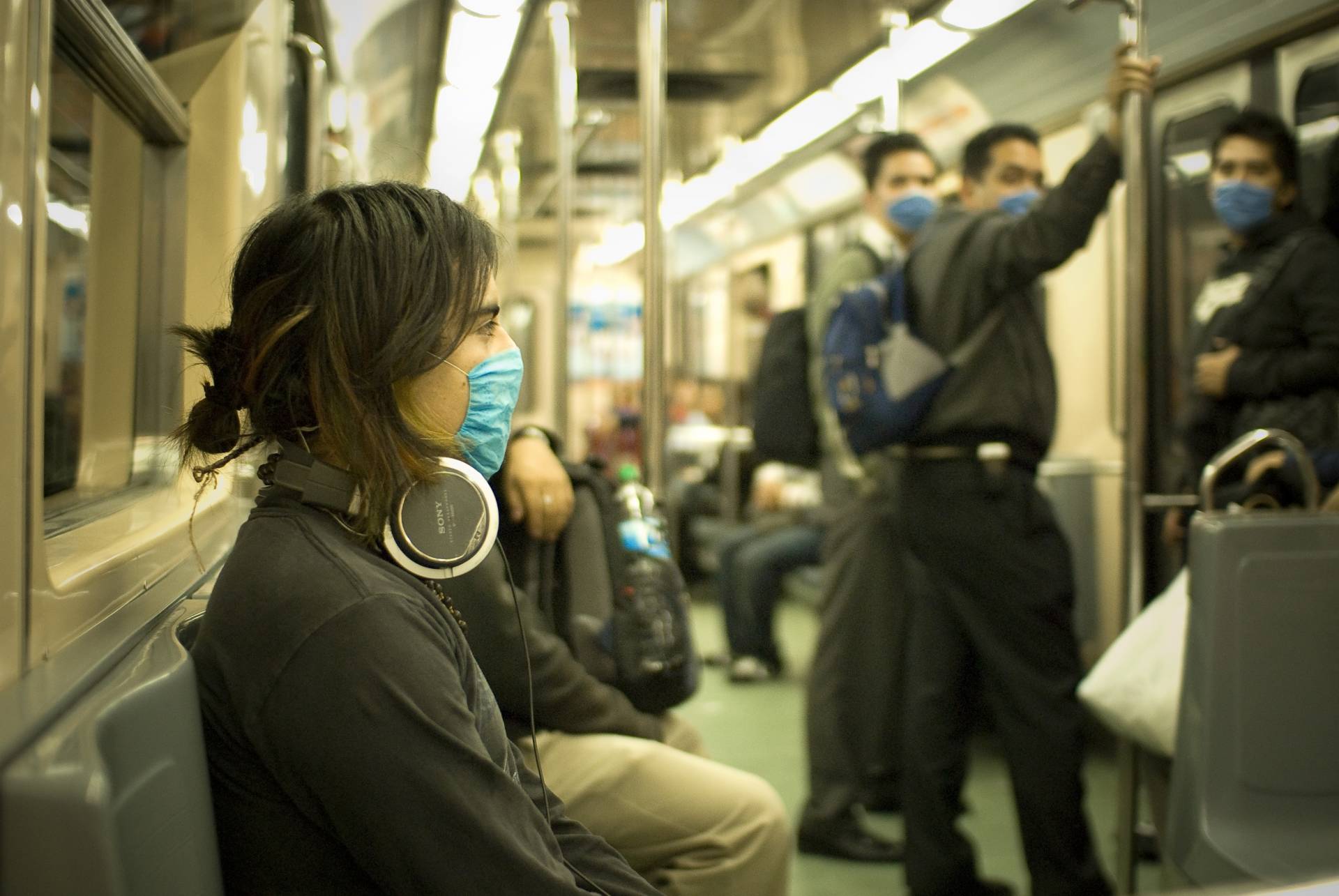 Los pasajeros viajan en el metro con mascarilla para evitar el contagio de la gripe.