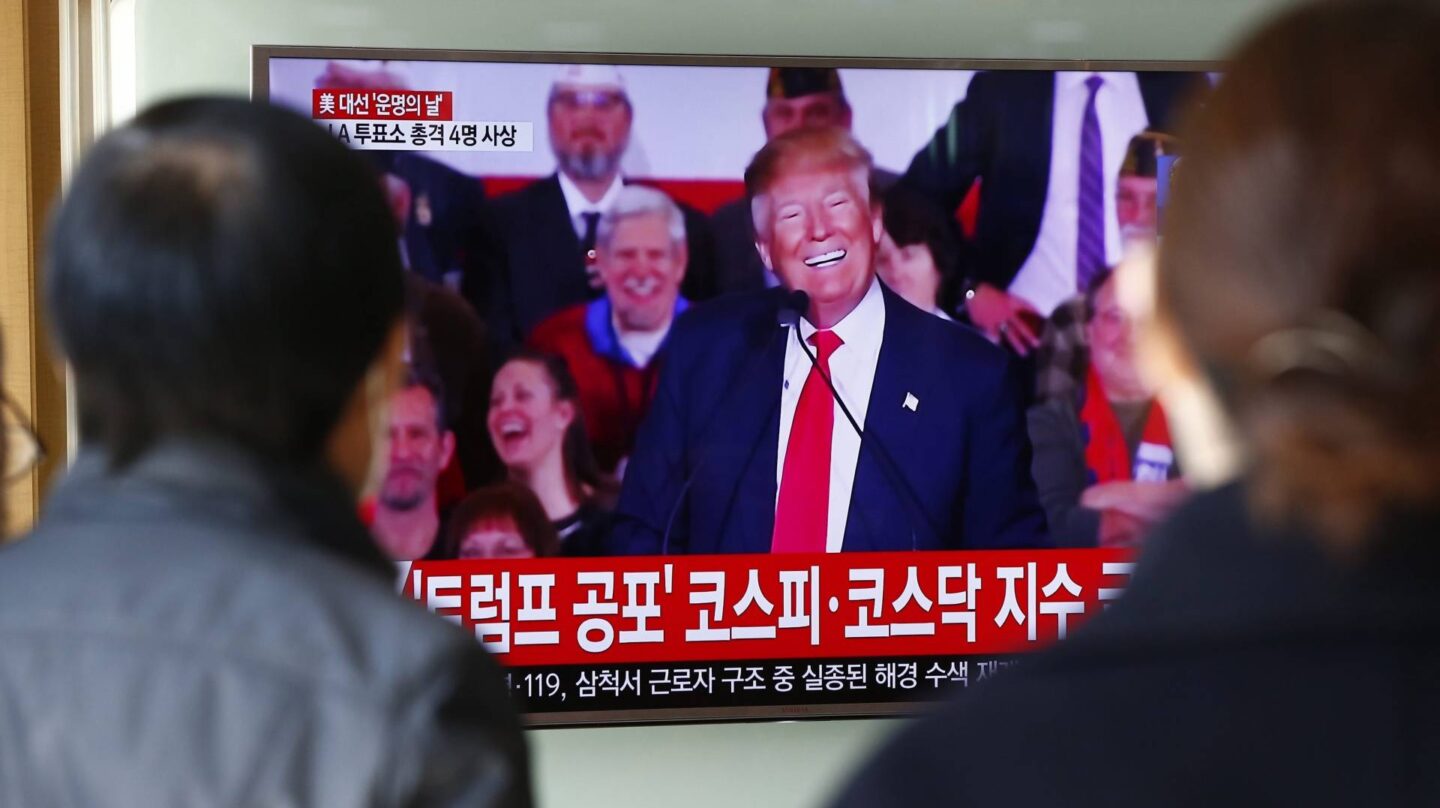 Dos personas, en Corea del Sur, ven por televisión un mítin de Donald Trump.