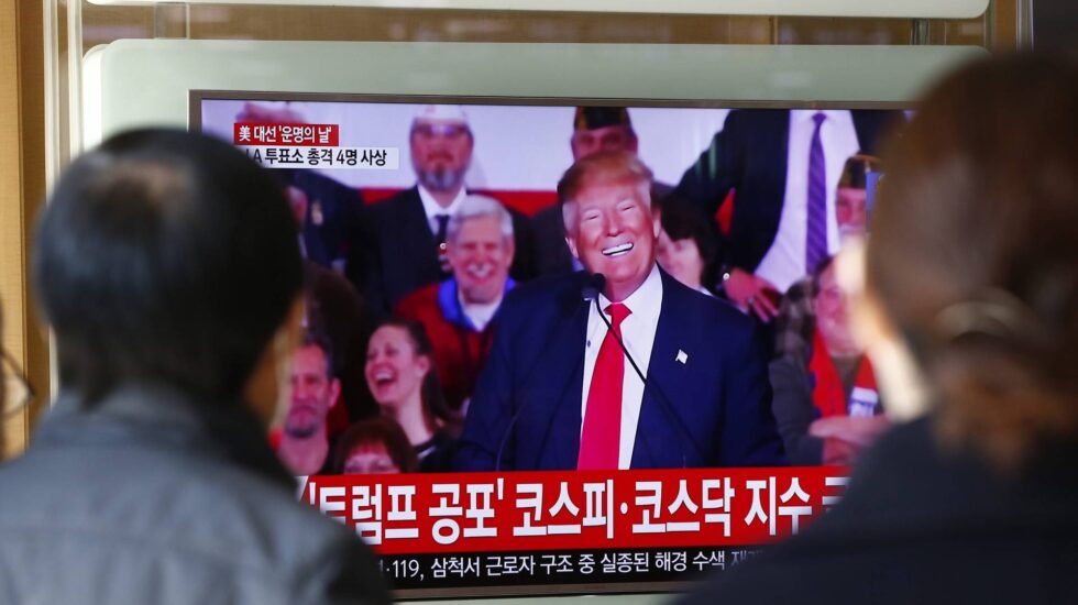 Dos personas, en Corea del Sur, ven por televisión un mítin de Donald Trump.
