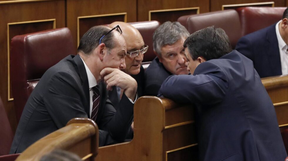 El portavoz del PNV, Aitor Esteban (d), conversa con diputados de su grupo, en el pleno del Congreso de los Diputados.