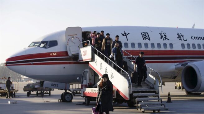 Viajeros descienden de un avión en un aeropuerto de China.