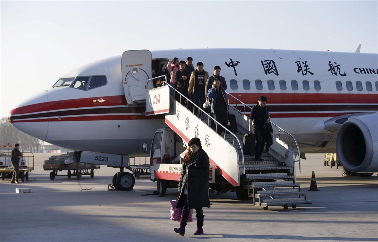 Viajeros descienden de un avión en un aeropuerto de China.