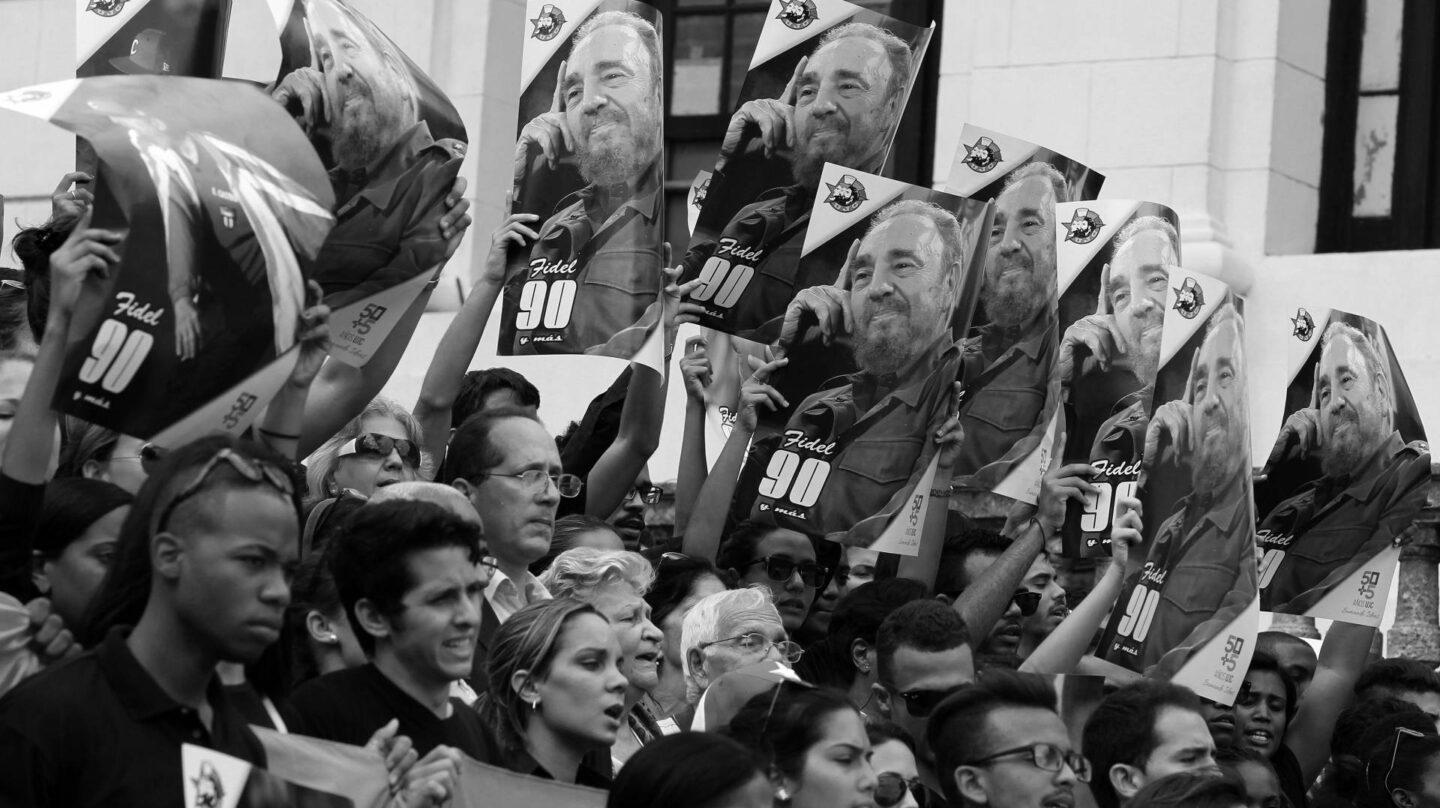 Cientos de cubanos aclaman a Fidel Castro y muestran su imagen en las manos.