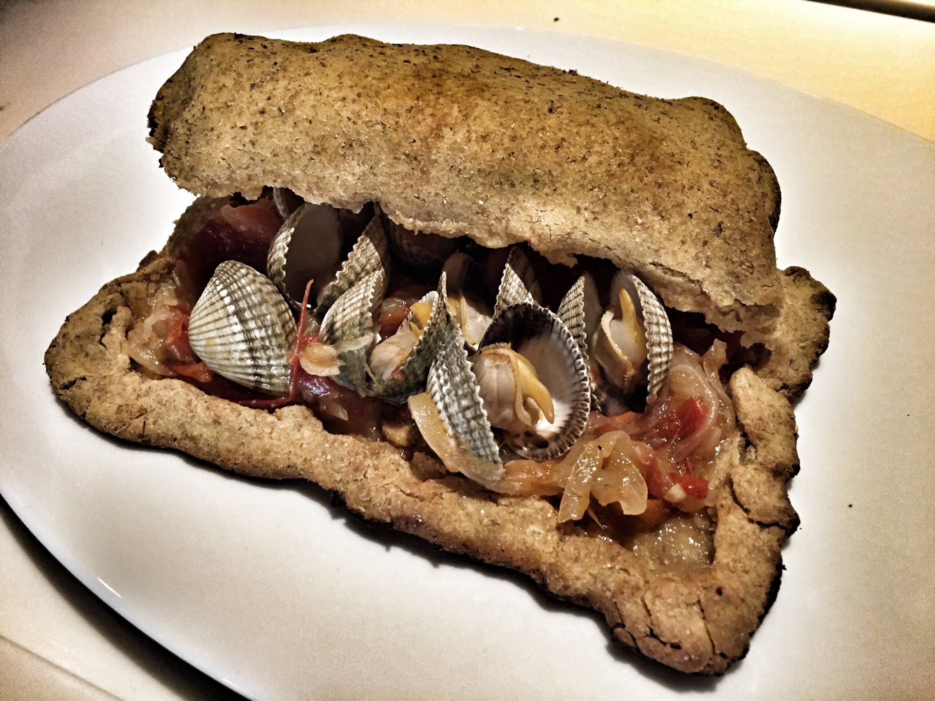 Una empanada de berberechos con su concha.