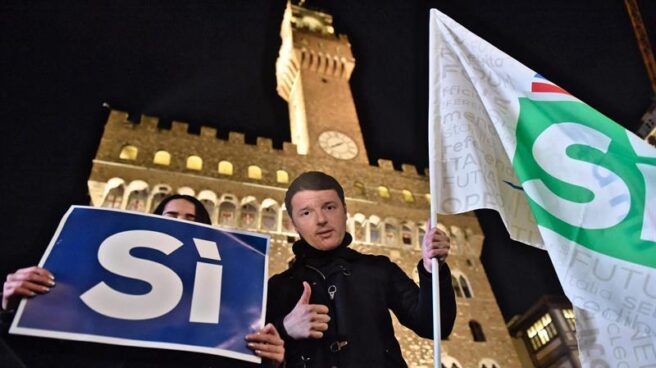 Una persona con una careta con la imagen de Renzi, en el acto final de campaña del referéndum en Italia.