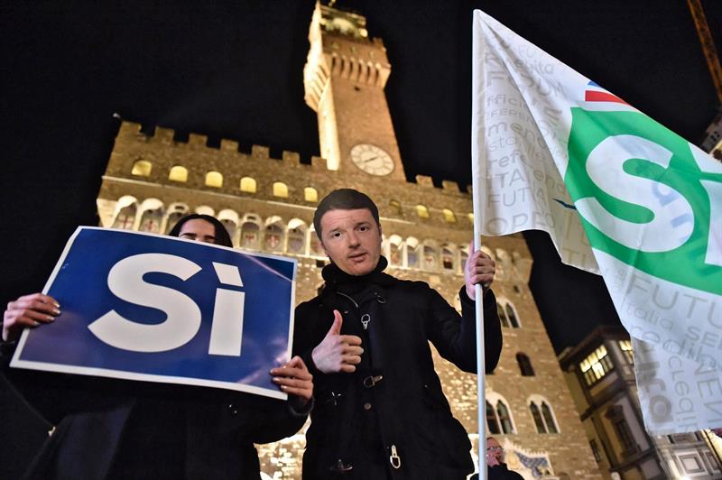 Una persona con una careta con la imagen de Renzi, en el acto final de campaña del referéndum en Italia.