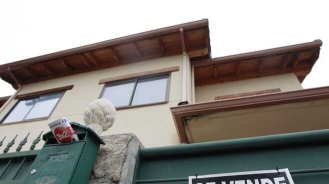 Una vivienda con un cartel de "se vende" en su fachada.