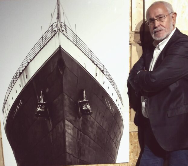 Jesus Ferreiro, presidente de la Fundación Titanic, posa junto a una imagen de la proa del Titanic.