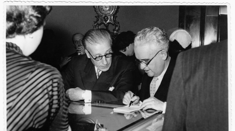 Alejandro Grassy y el ingeniero André Thomas Belin, antiguos compañeros de la Resistencia francesa, apoyados sobre el reloj parlante el día de la inauguración de Grassy (7 de mayo de 1953).
