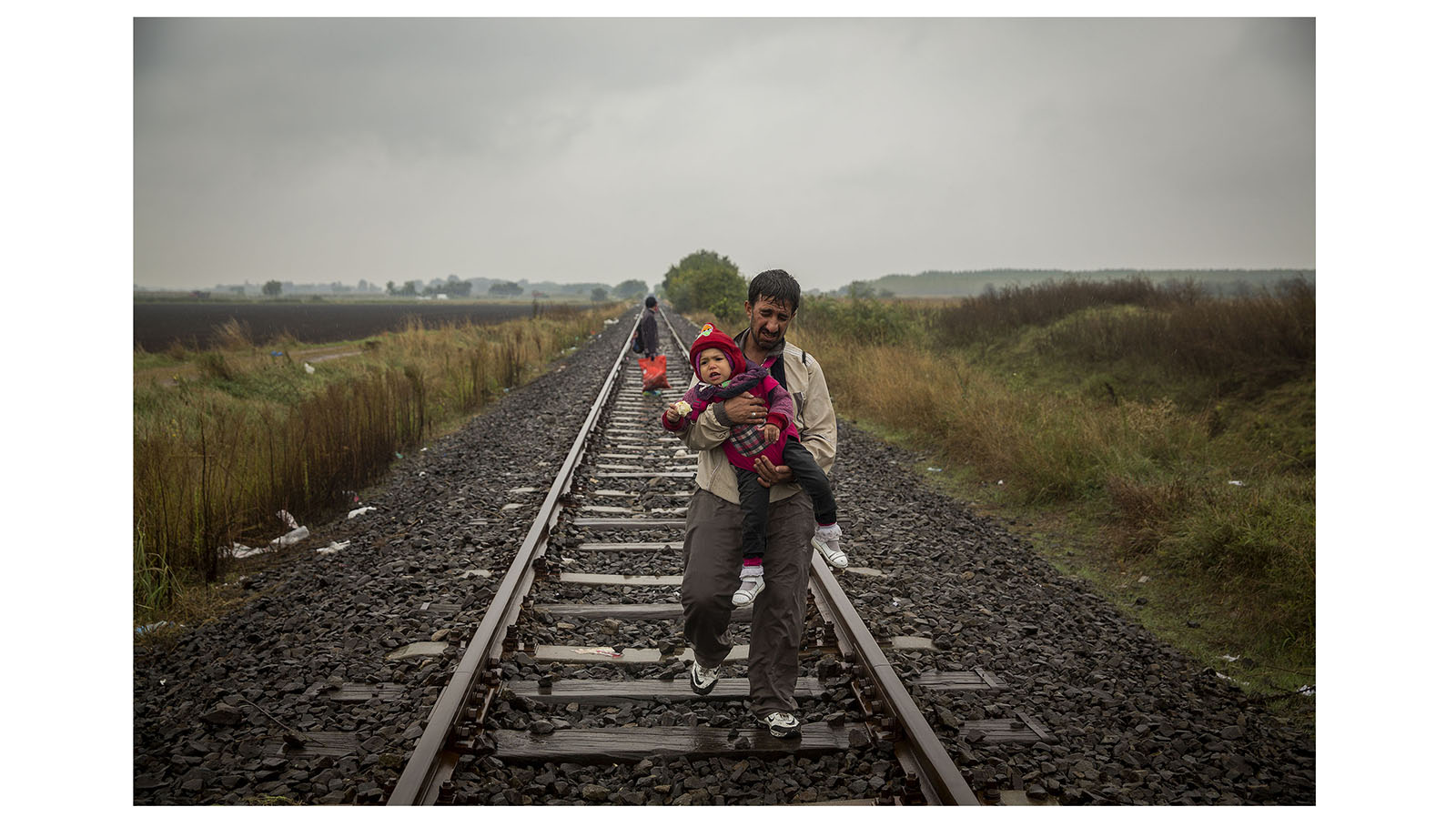 Olmo Calvo. Supervivientes en busca de refugio. 2015-2016 Miles de personas procedentes de países como Siria, Irak o Afganistán abandonaron sus casas huyendo del horror de la guerra, buscando un refugio en Europa donde reanudar su vida. Un periplo en el que familias enteras caminan durante días, viajan en botes hinchables y trenes, aferradas a sus mochilas como únicas pertenencias.