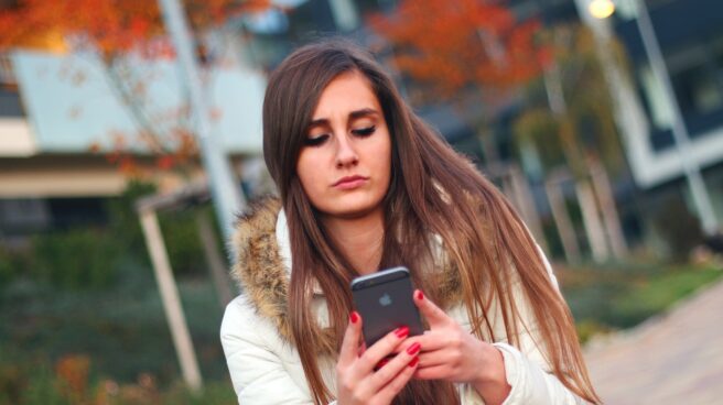 iphone Una joven utiliza su Iphone.