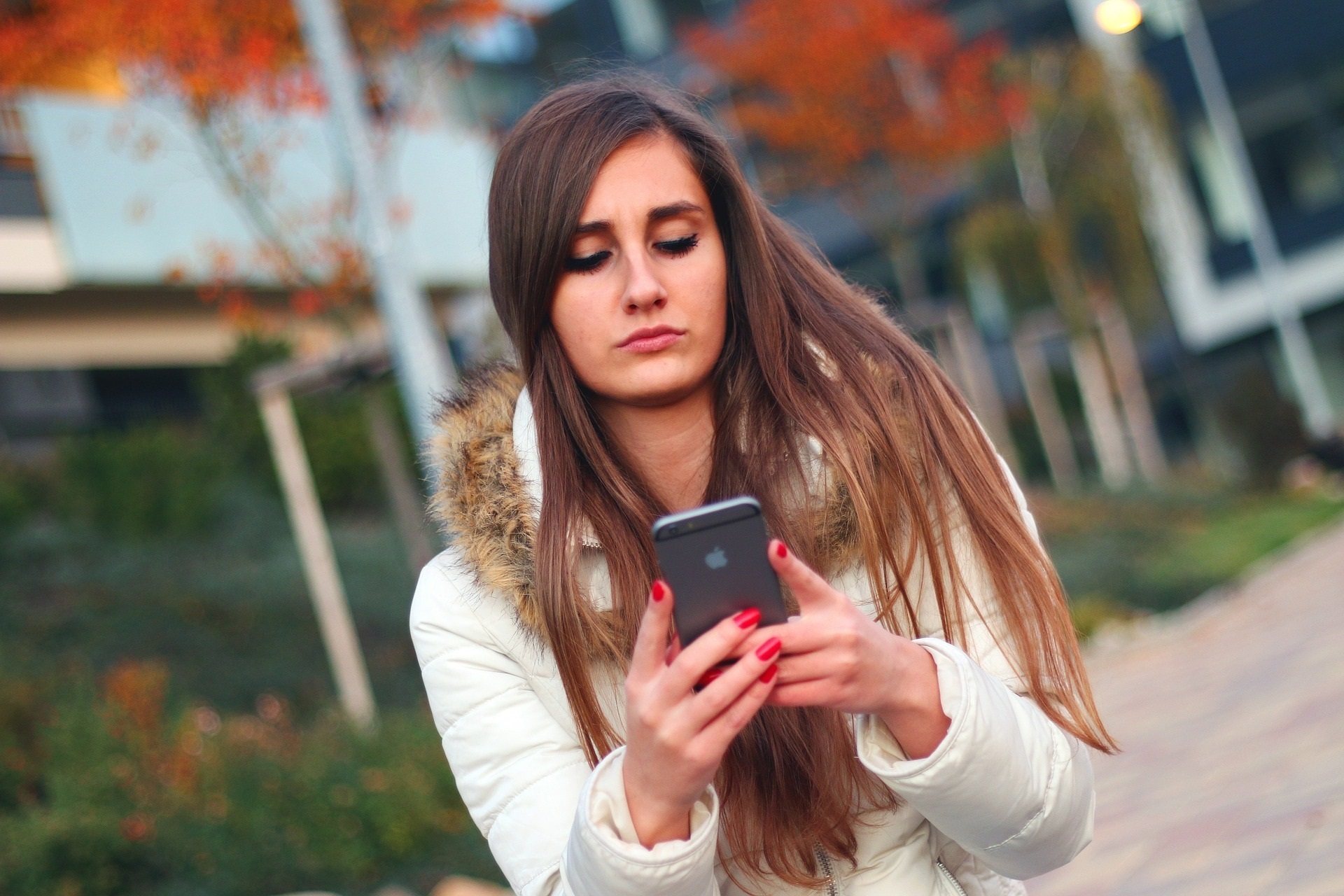 Una joven utiliza su Iphone.