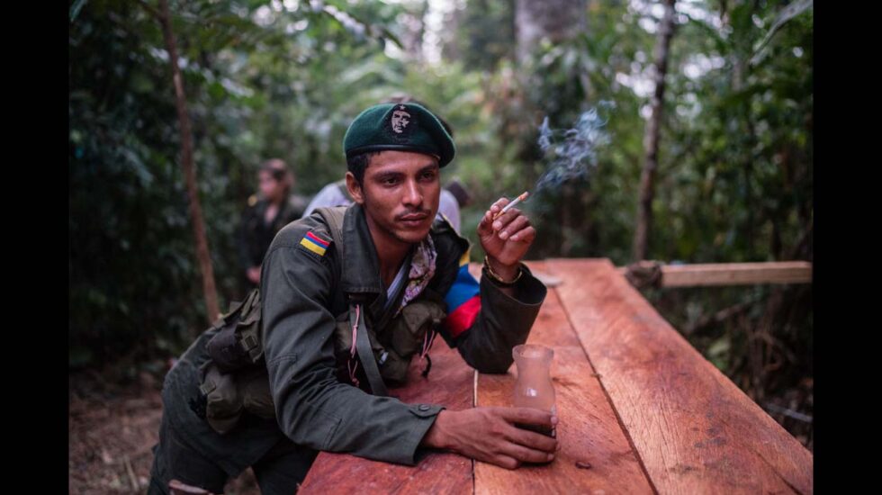 Un miembro de las FARC fumando un cigarrillo con su primer café de la mañana, en la profunda selva colombiana. Federico Rios / ©Native Agency.