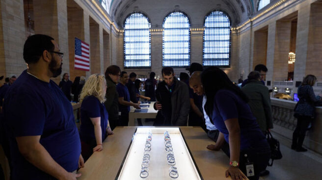 Compradores ante un expositor con Apple Watch en una de las tiendas de la compañía.