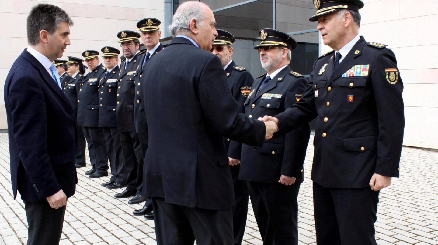 Jorge Fernández Díaz, entonces ministro del Interior, estrecha la mano a Eugenio Pino en presencia de Ignacio Cosidó en un acto de la Policía.