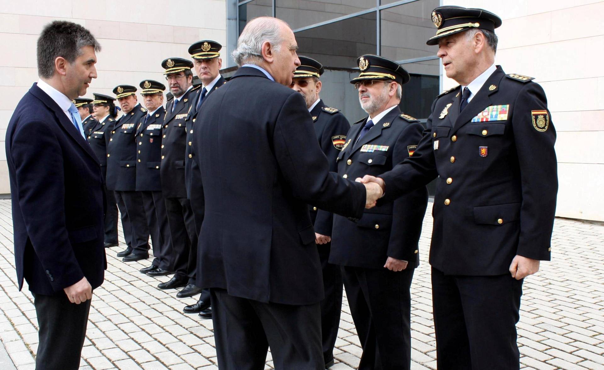 Jorge Fernández Díaz, entonces ministro del Interior, estrecha la mano a Eugenio Pino en presencia de Ignacio Cosidó en un acto de la Policía.