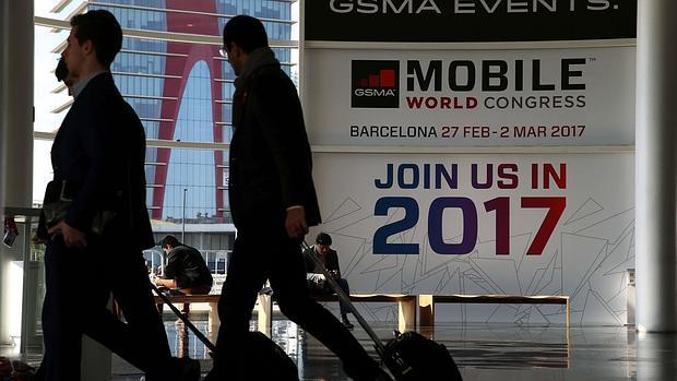 Dos visitantes ante un cartel publicitario del Mobile World Congress.