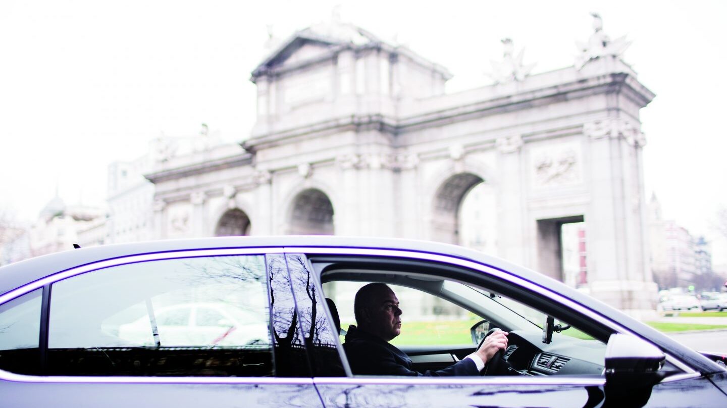 Un coche de Uber, circulando por la Puerta de Alcalá en Madrid.