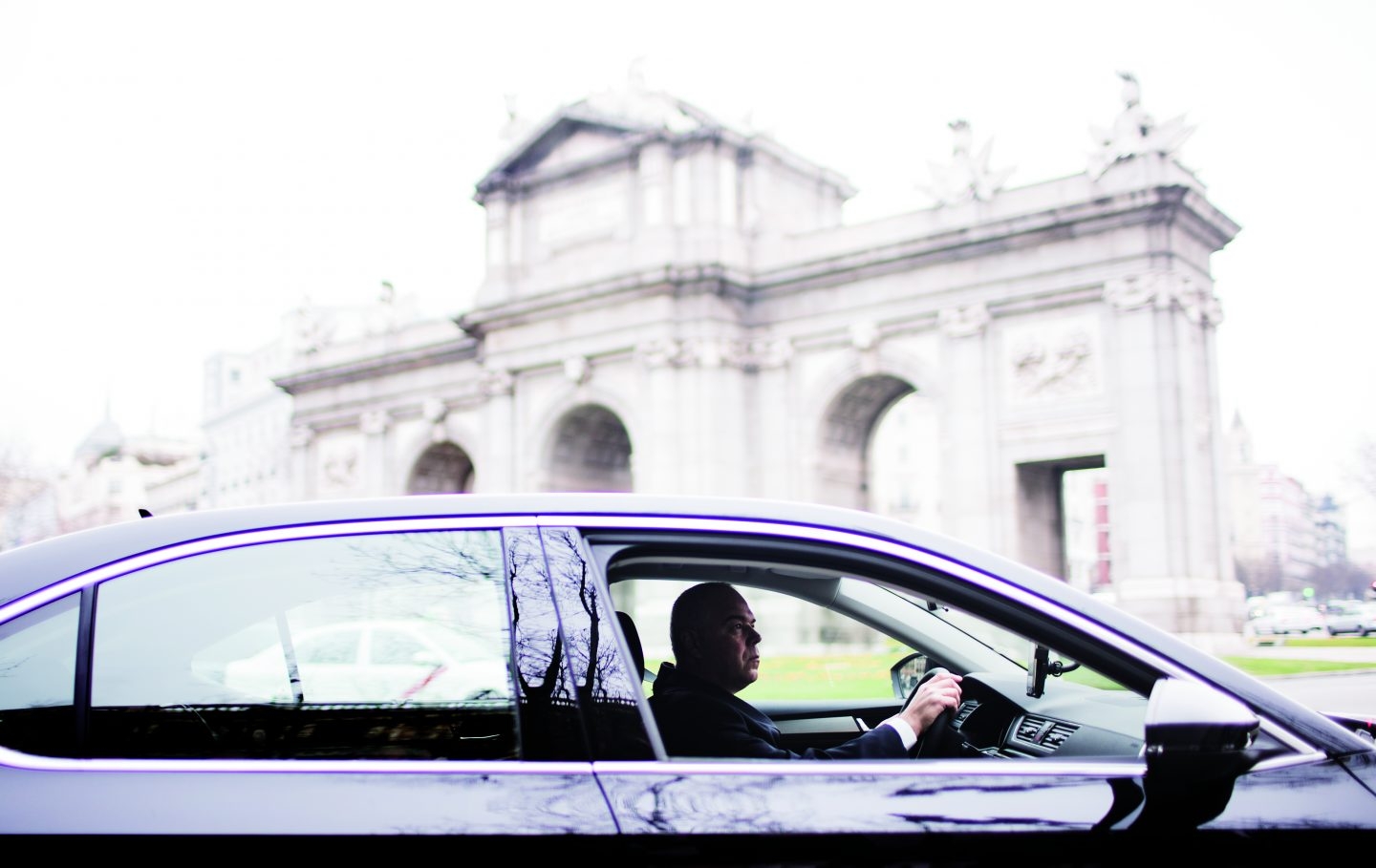 Un coche de Uber, circulando por la Puerta de Alcalá en Madrid.
