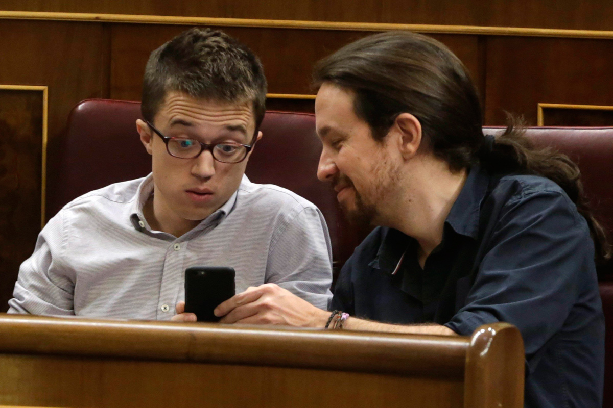 Pablo Iglesias e Íñigo Errejón, mirando un teléfono móvil.