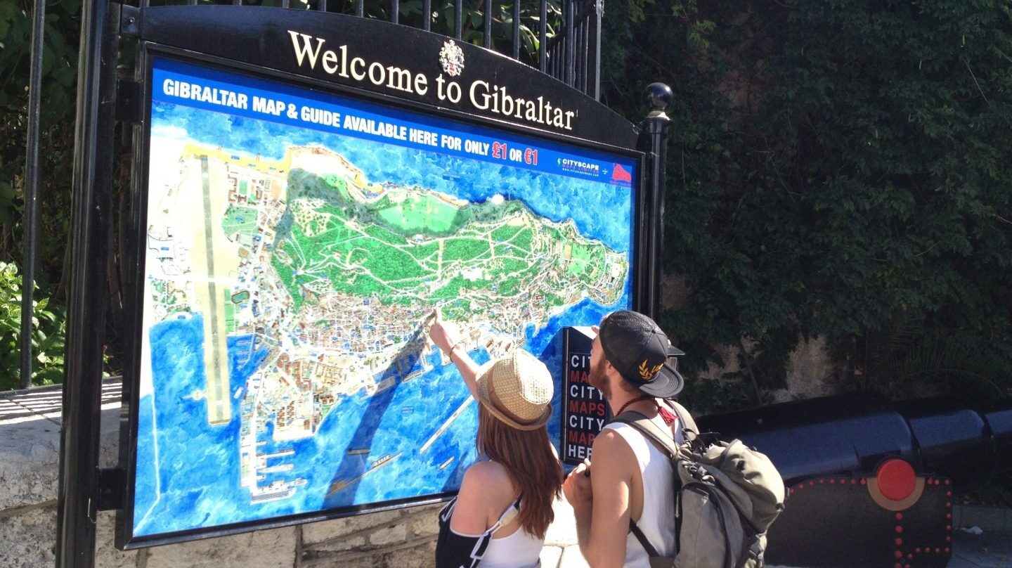 Una pareja de turistas observan el mapa de Gibraltar.