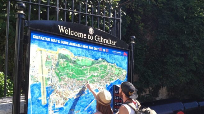 Una pareja de turistas observan el mapa de Gibraltar.
