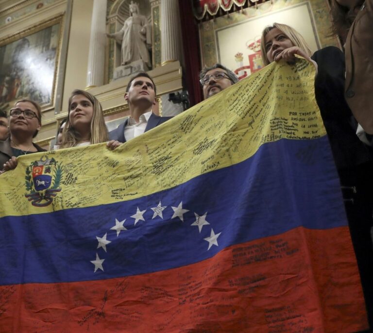 Una opositora venezolana posa con una bandera en el escaño de Pablo Iglesias