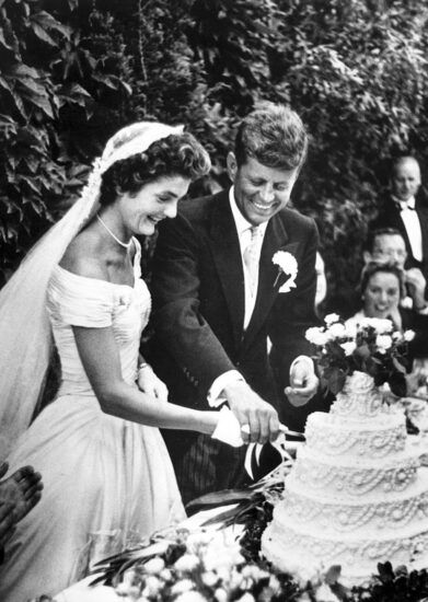 John F. Kennedy (d) junto a Jacqueline Bouvier Kennedy, mientras cortan su pastel de bodas en Newport, Rhode Island, Estados Unidos el 12 de septiembre de 1953.