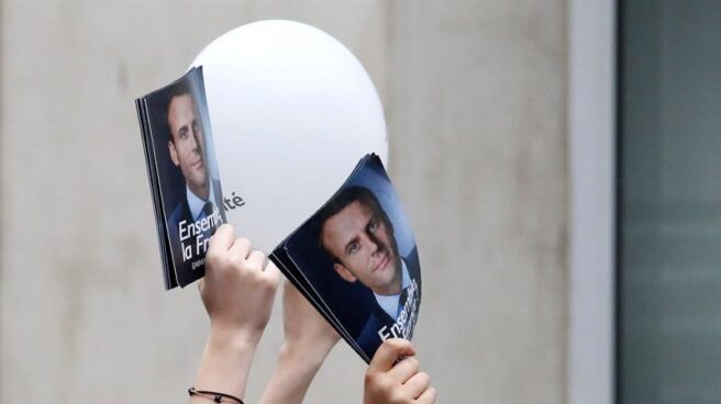 Seguidores de Emmanuel Macron muestran imágenes suyas para celebrar su victoria.
