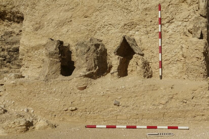 Pequeña capilla de adobe con tres estelas o lápidas de piedra en su interior.