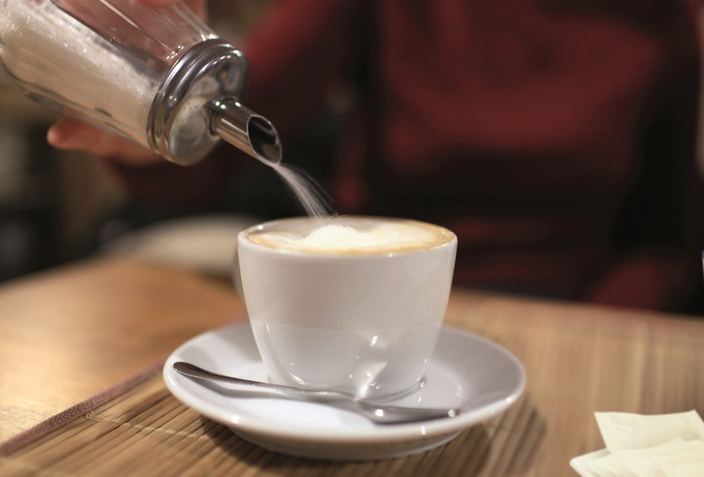 Taza de café con leche y azúcar.