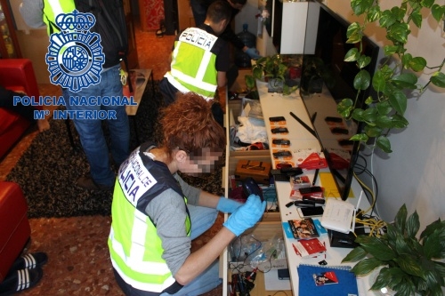 teléfonos móviles incautados Una policía, junto a los terminales intervenidos en el operativo.