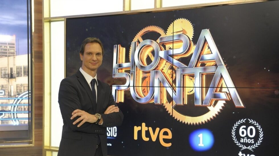 Javier Cárdenas posando frente a la publicidad de Hora Punta