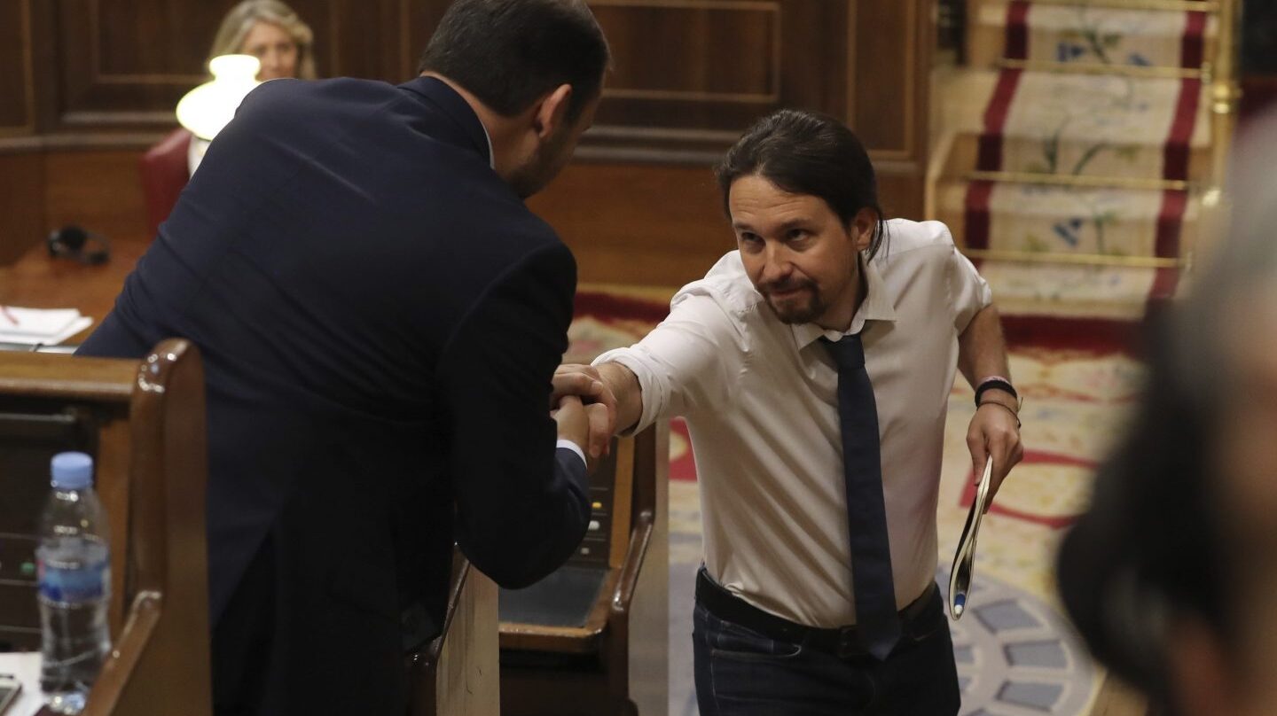 El líder de Podemos, Pablo Iglesias, da la mano al portavoz socialista, José Luis Ábalos, durante el debate.
