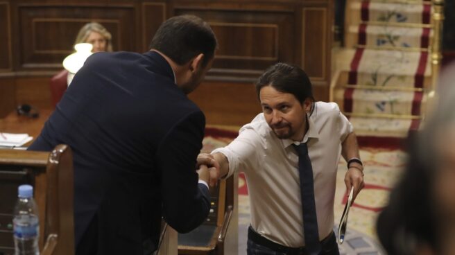 El líder de Podemos, Pablo Iglesias, da la mano al portavoz socialista, José Luis Ábalos, durante el debate.