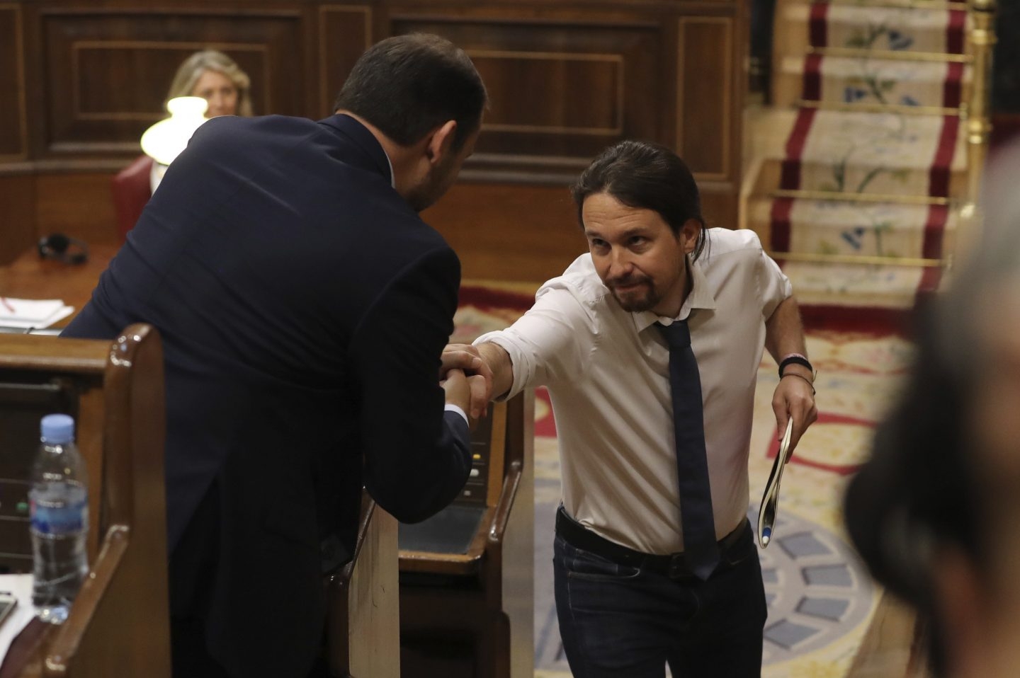 El líder de Podemos, Pablo Iglesias, da la mano al portavoz socialista, José Luis Ábalos, durante el debate.