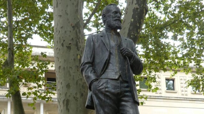 El portavoz del PNV en el Congreso, Aitor Esteban, junto a la estatua en honor de Sabino Arana ubicada ante la sede del PNV.