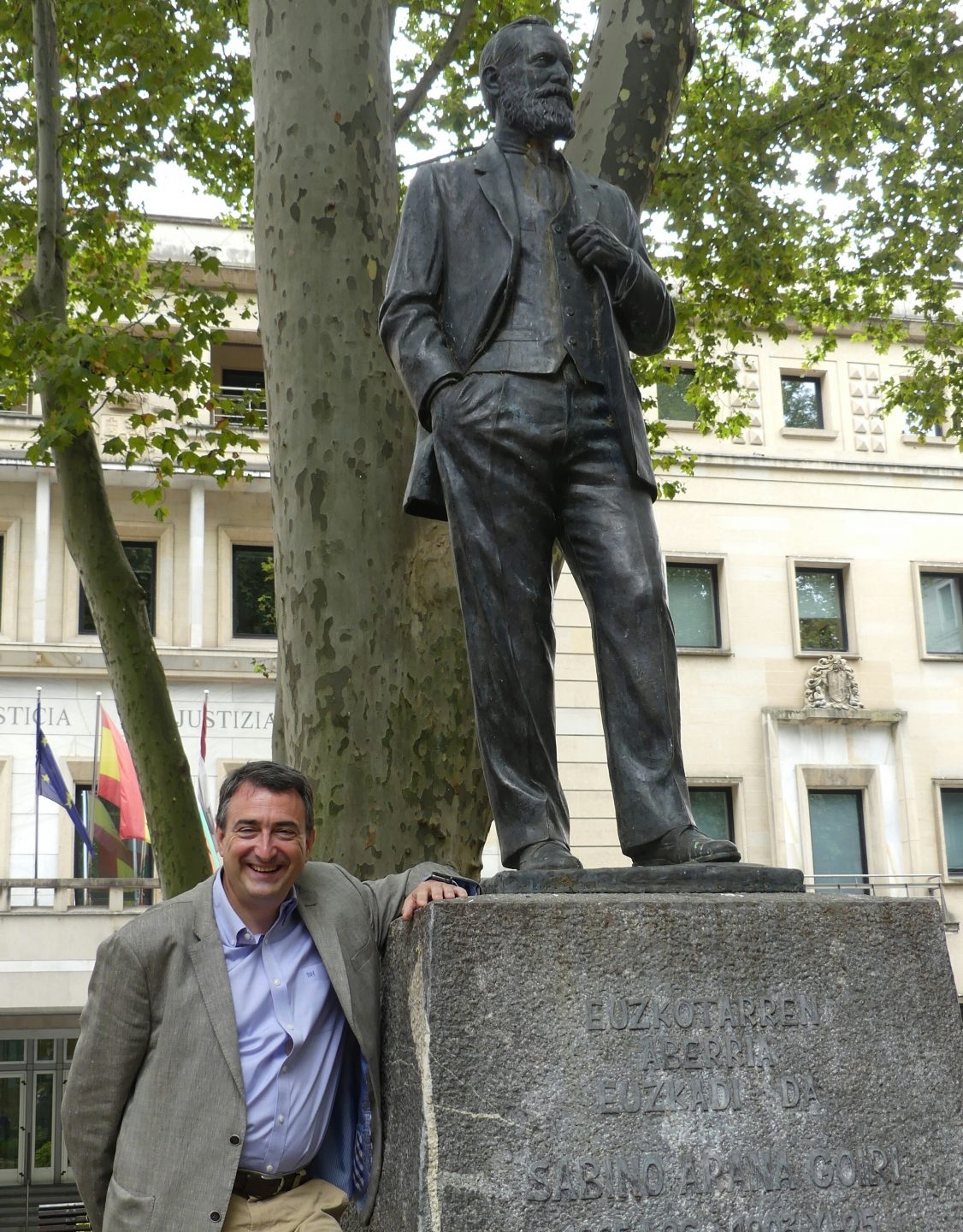 El portavoz del PNV en el Congreso, Aitor Esteban, junto a la estatua en honor de Sabino Arana ubicada ante la sede del PNV.