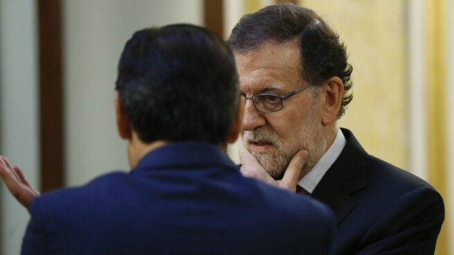El presidente del Gobierno, Mariano Rajoy (d) conversa con el diputado del PP, Fernando Martínez-Maíllo, en los pasillos del Congreso de los Diputados.