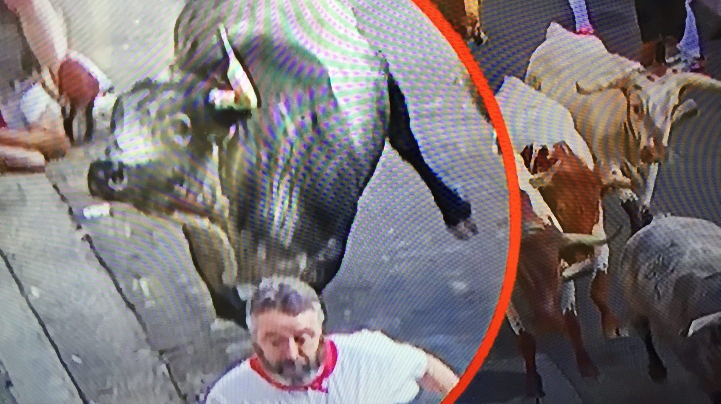 Encierro de San Fermín: el toro 80 de Cebada Gago cornea a un corredor.