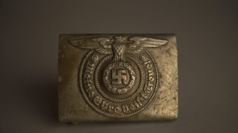 Hebilla metálica de cinturón de las SS nazis, colección del Museo Estatal de Auschwitz-Birkenau Foto por Pawel Sawicki © Auschwitz-Birkenau State Museum - Musealia