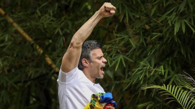 Leopoldo López saluda desde la verja de su casa en Caracas.