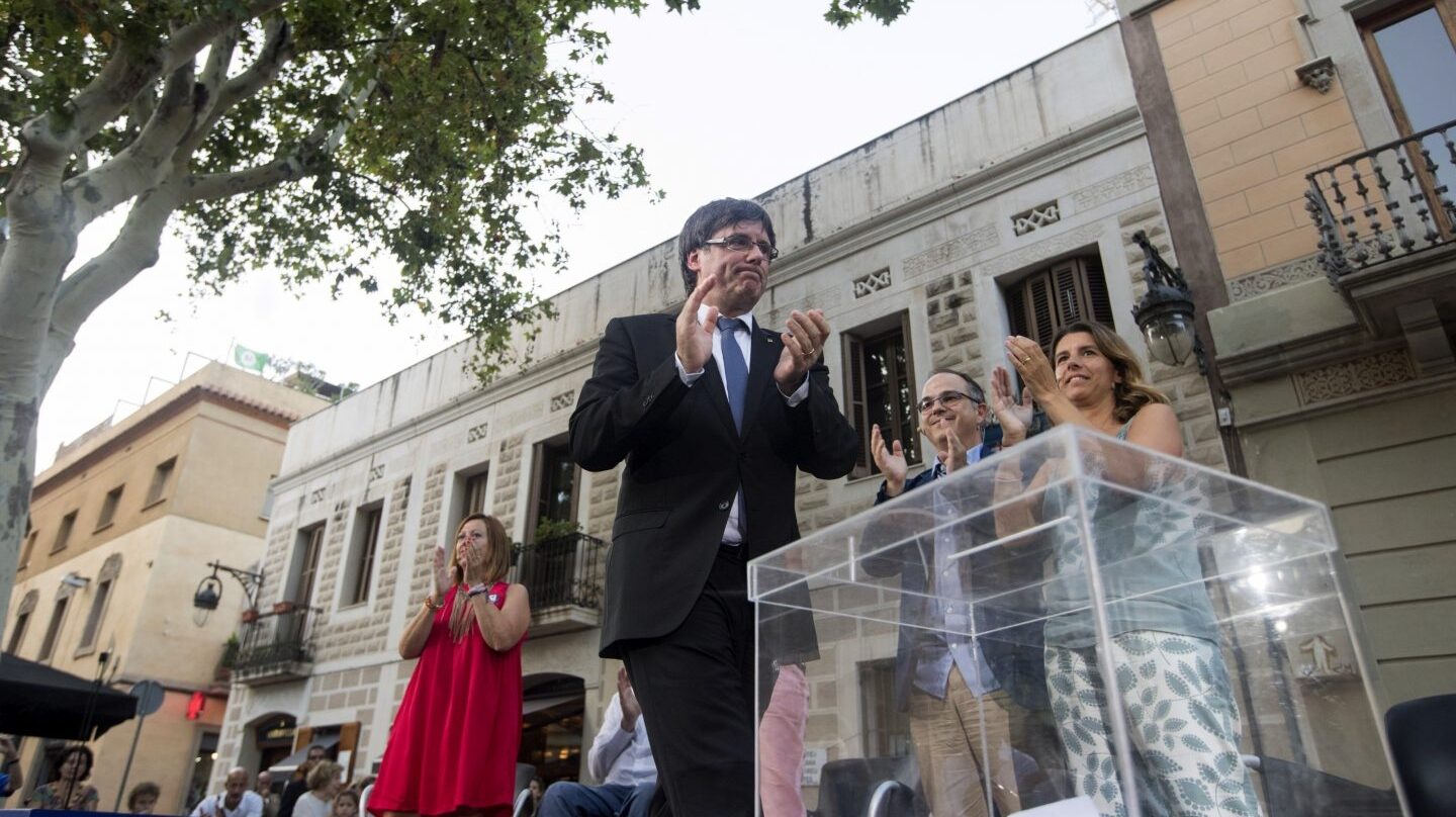 El 'president' de la Generalitat, Carles Puigdemont, junto a una urna simbólica.