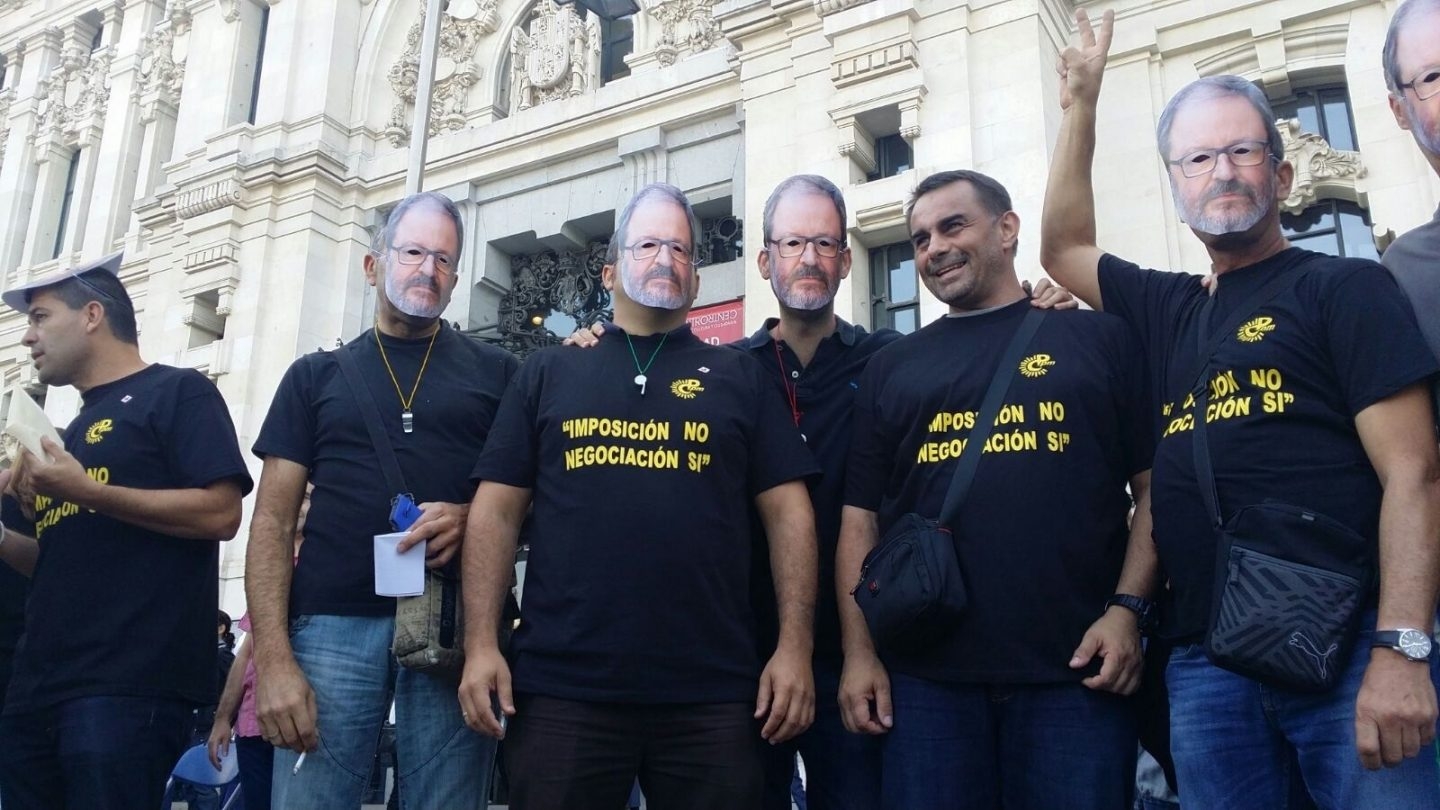 Varios manifestantes con la careta del delegado de Seguridad Javier Barbero.