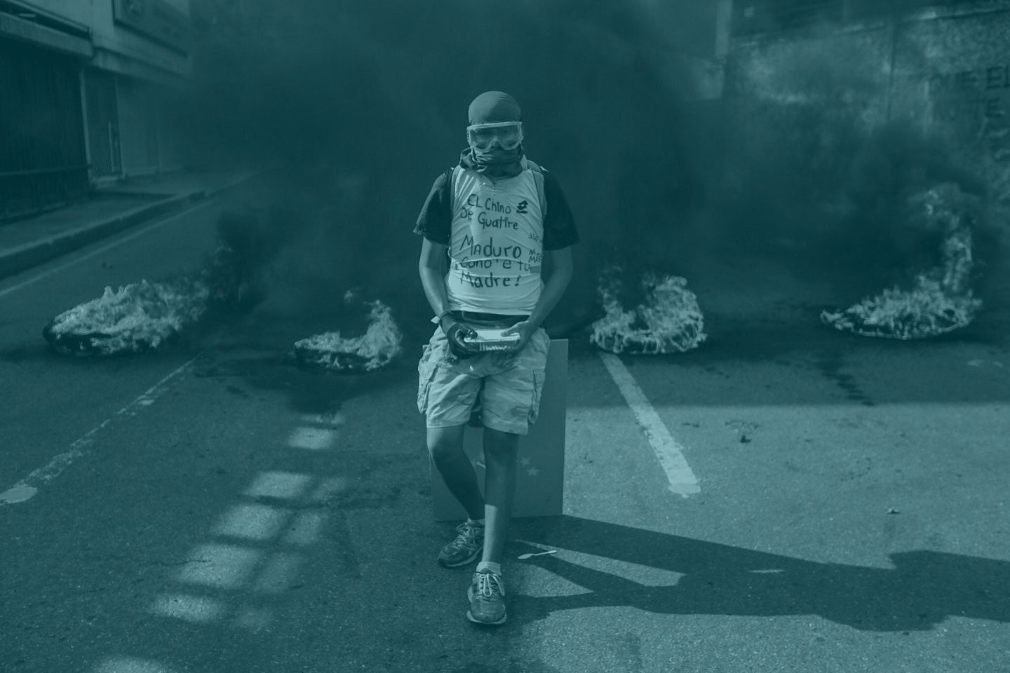 Un manifestante permanece en frente de una barricada en llamas durante una manifestación en Venezuela.