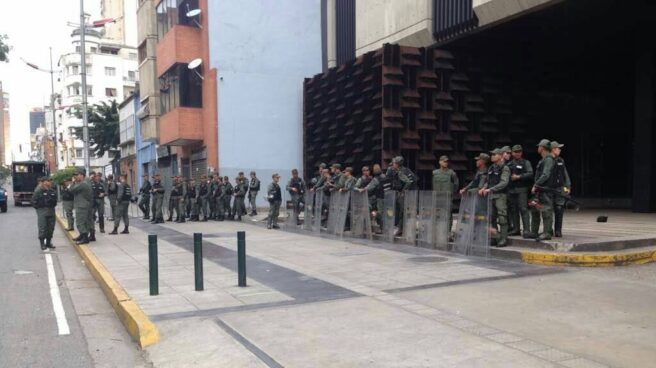 Agentes de la policía venezolana asedian la Fiscalía General de la República, en Caracas.
